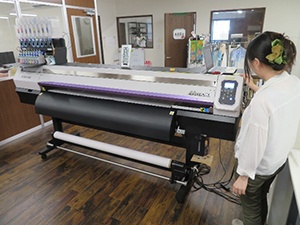 Two female designers operate the printer.