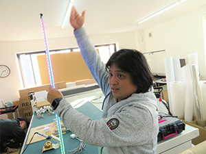 "Prints need your idea," says President Yamazaki. In his hand is a pole for banners, whose color is changed by LED.